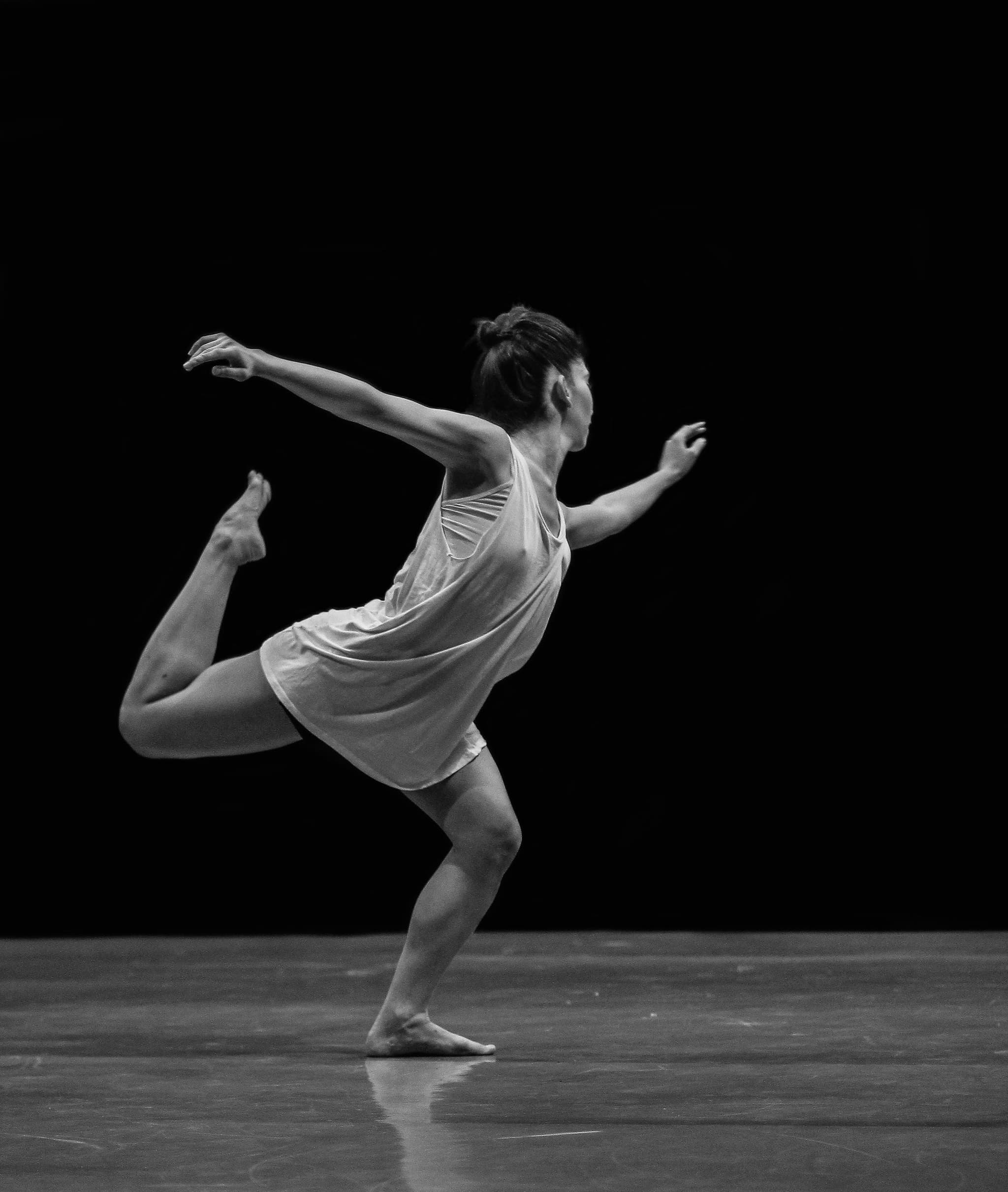 Ballet dancer mid-leap on an empty stage